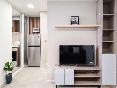 Modern living room with sleek TV unit and open kitchen layout, perfect for contemporary living.
