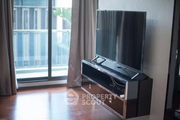 Modern living room with sleek TV stand and large window view.