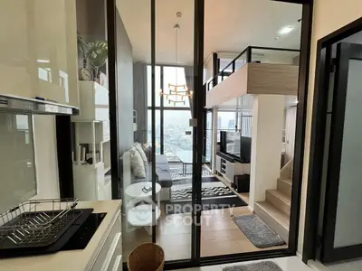 Modern loft apartment with open living area and city view, featuring stylish decor and high ceilings.