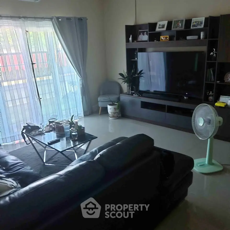 Spacious living room with modern entertainment center and large windows