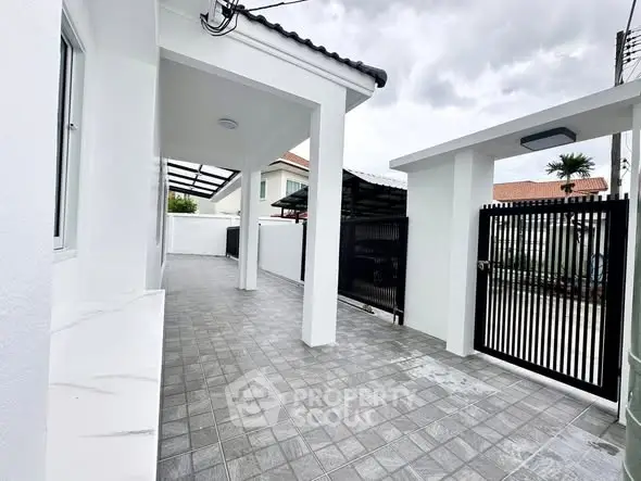 Modern residential entrance with sleek gate and tiled pathway