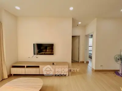 Spacious living room with modern minimalist decor, sleek wooden flooring, and ample natural light, perfect for comfortable urban living.