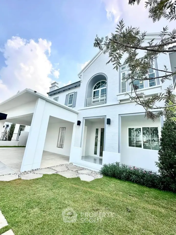 Stunning modern white house with lush green lawn and spacious driveway, perfect for family living.