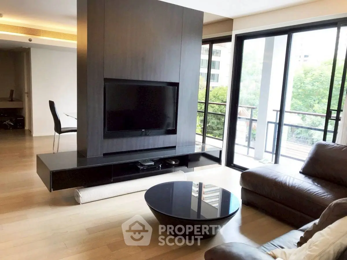 Spacious modern living room with large windows and sleek furniture in a luxury apartment.