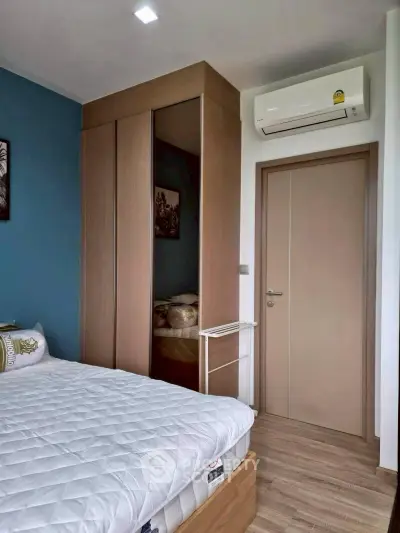 Modern bedroom with sleek wardrobe and air conditioning in stylish apartment.