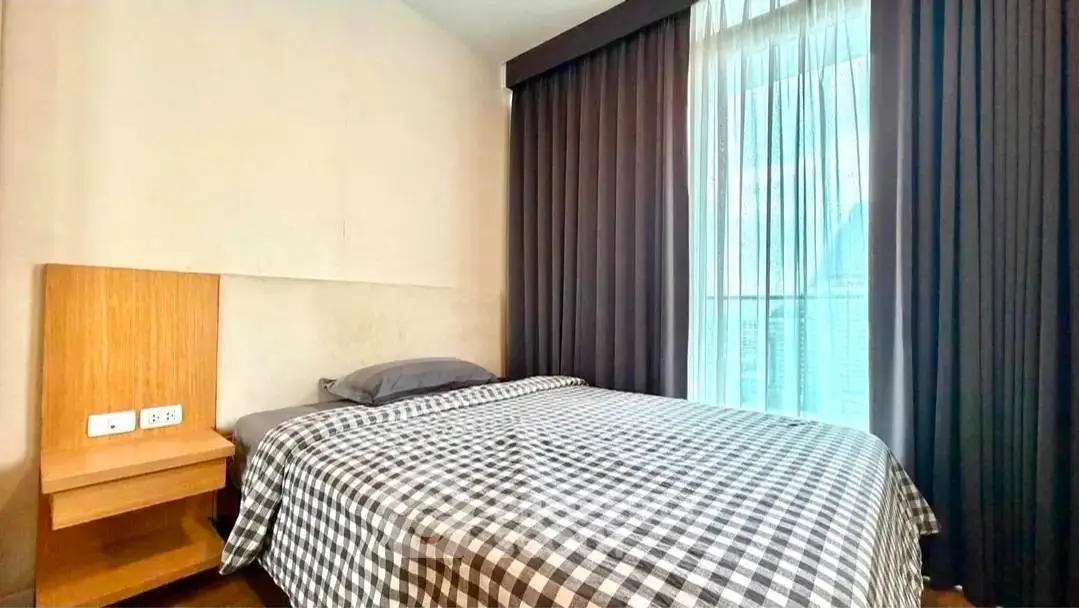 Cozy bedroom with checkered bedding and large window with curtains