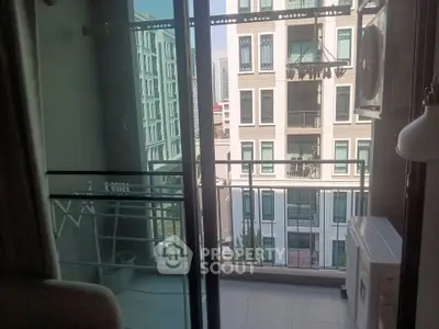 Modern apartment balcony with glass railing and city view, perfect for urban living.
