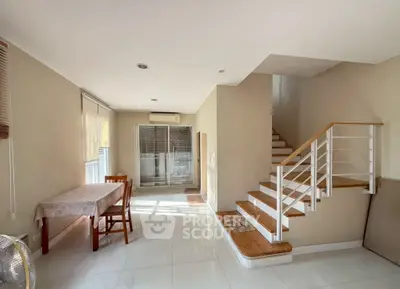 Spacious modern living room with elegant staircase and dining area, perfect for family gatherings.