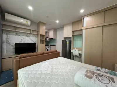 Modern studio apartment with integrated kitchen and living area, featuring stylish furniture and appliances.