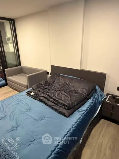 Modern bedroom with stylish bed and cozy sofa in a contemporary apartment.