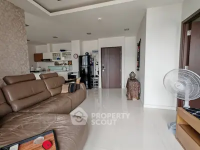Spacious modern living room with leather sofa and open kitchen layout