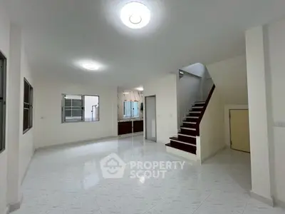 Spacious open-plan living area with modern staircase and large windows