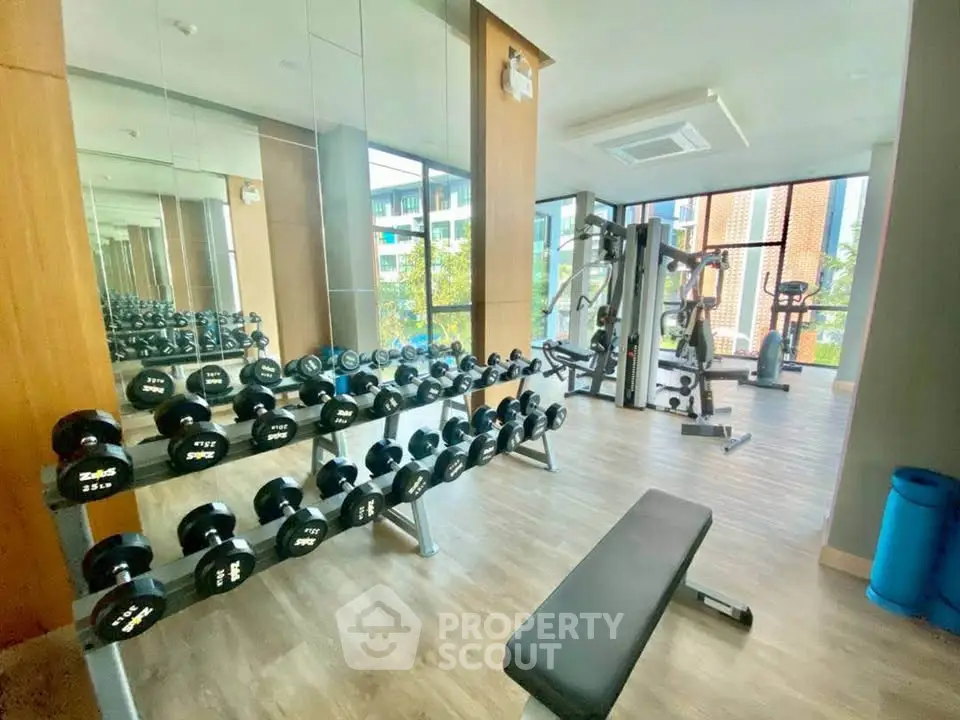 Modern gym with state-of-the-art equipment and large windows offering natural light.