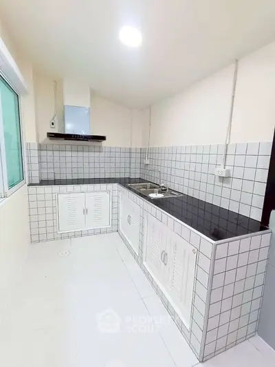 Sleek modern kitchen with tiled backsplash and ample counter space