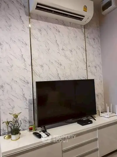 Modern living room with sleek TV setup and air conditioning unit, perfect for comfortable living.