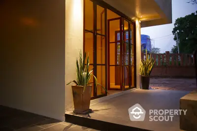 Charming entrance with warm lighting and potted plants, perfect for welcoming guests.