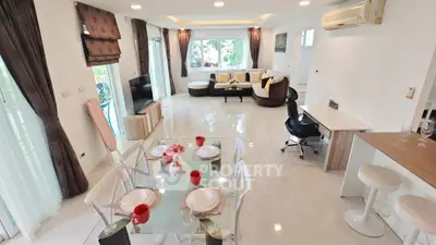 Spacious modern living room with dining area, featuring elegant decor and ample natural light.