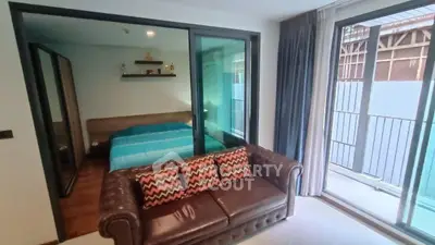 Modern apartment with cozy living room and bedroom, featuring large windows and stylish decor.