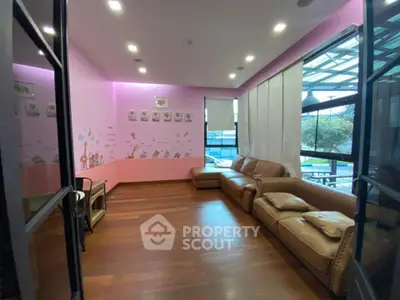 Charming living room with pink walls and cozy leather sofa, perfect for family gatherings.