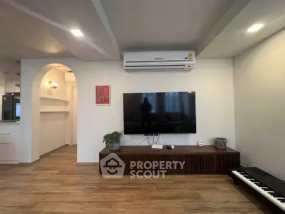 Modern living room with wall-mounted TV and air conditioning unit