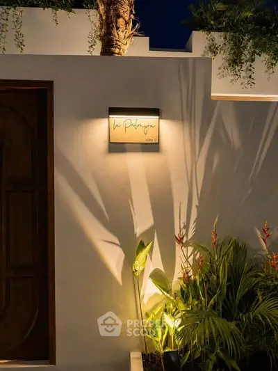 Elegant villa entrance with ambient lighting and lush greenery