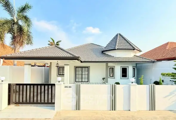 Charming single-story house with tiled roof and gated entrance in a serene neighborhood.