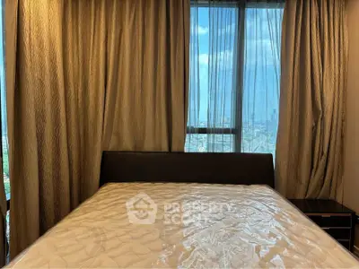Spacious bedroom with large window offering stunning city views, perfect for urban living.
