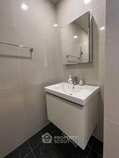 Modern bathroom with sleek vanity and mirror in contemporary design.