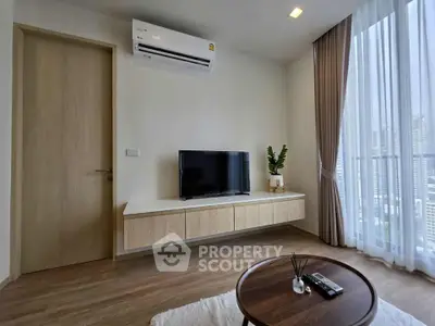Modern living room with TV, air conditioning, and large window view.