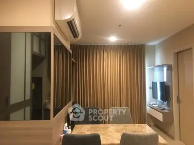 Modern living room with dining area and wall-mounted TV in cozy apartment.