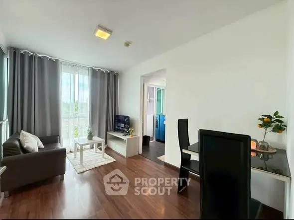 Bright and modern living room with dining area and large windows in a stylish apartment.
