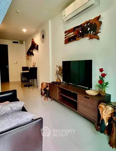 Modern living room with stylish decor and air conditioning, featuring a sleek TV stand and dining area.
