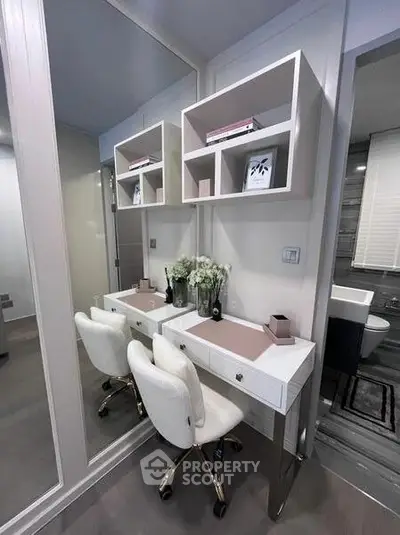Modern bathroom with elegant vanity and plush chairs, featuring sleek shelving and stylish decor.