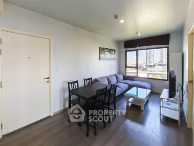 Modern living room with city view, featuring cozy sofa and dining area, perfect for urban living.