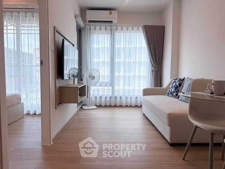 Modern living room with natural light, cozy sofa, and stylish decor in a contemporary apartment.