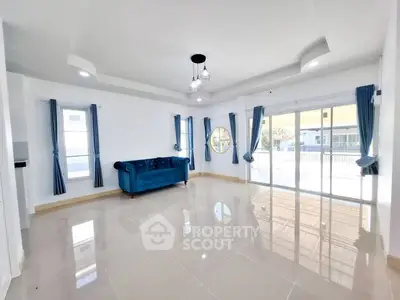Spacious living room with elegant blue sofa and large windows for natural light.