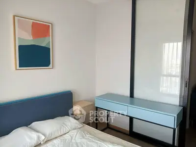 Modern bedroom with stylish decor and sleek furniture, featuring a blue headboard and abstract wall art.