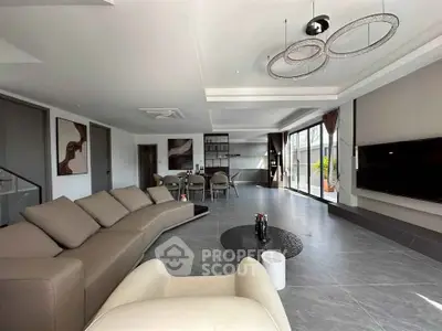Spacious modern living room with elegant decor and open layout, featuring a large sofa and stylish lighting.