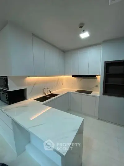 Modern kitchen with sleek white cabinetry and marble countertops