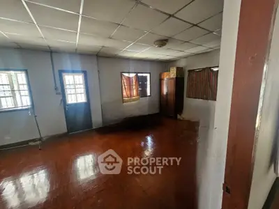 Spacious room with wooden flooring and natural light, ideal for versatile use in a residential property.