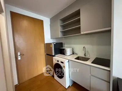 Modern compact kitchen with appliances and sleek cabinetry in a stylish apartment.
