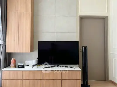 Modern living room with sleek TV setup and stylish wooden cabinetry.