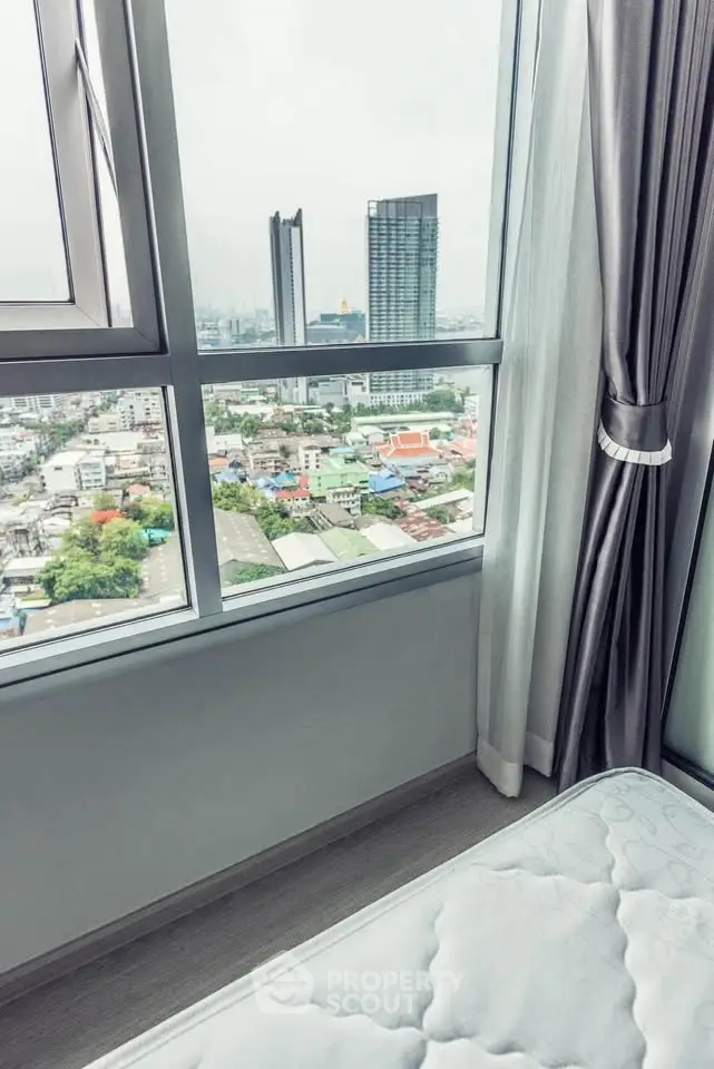 Stunning city view from a modern bedroom window in a high-rise apartment.