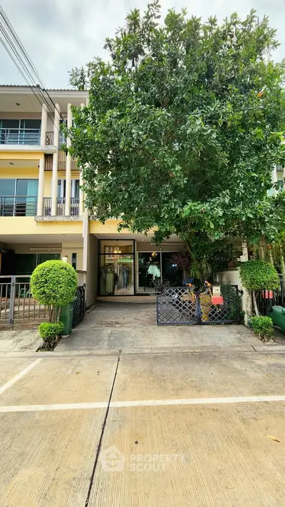 Charming townhouse with lush greenery and spacious driveway, perfect for modern living.