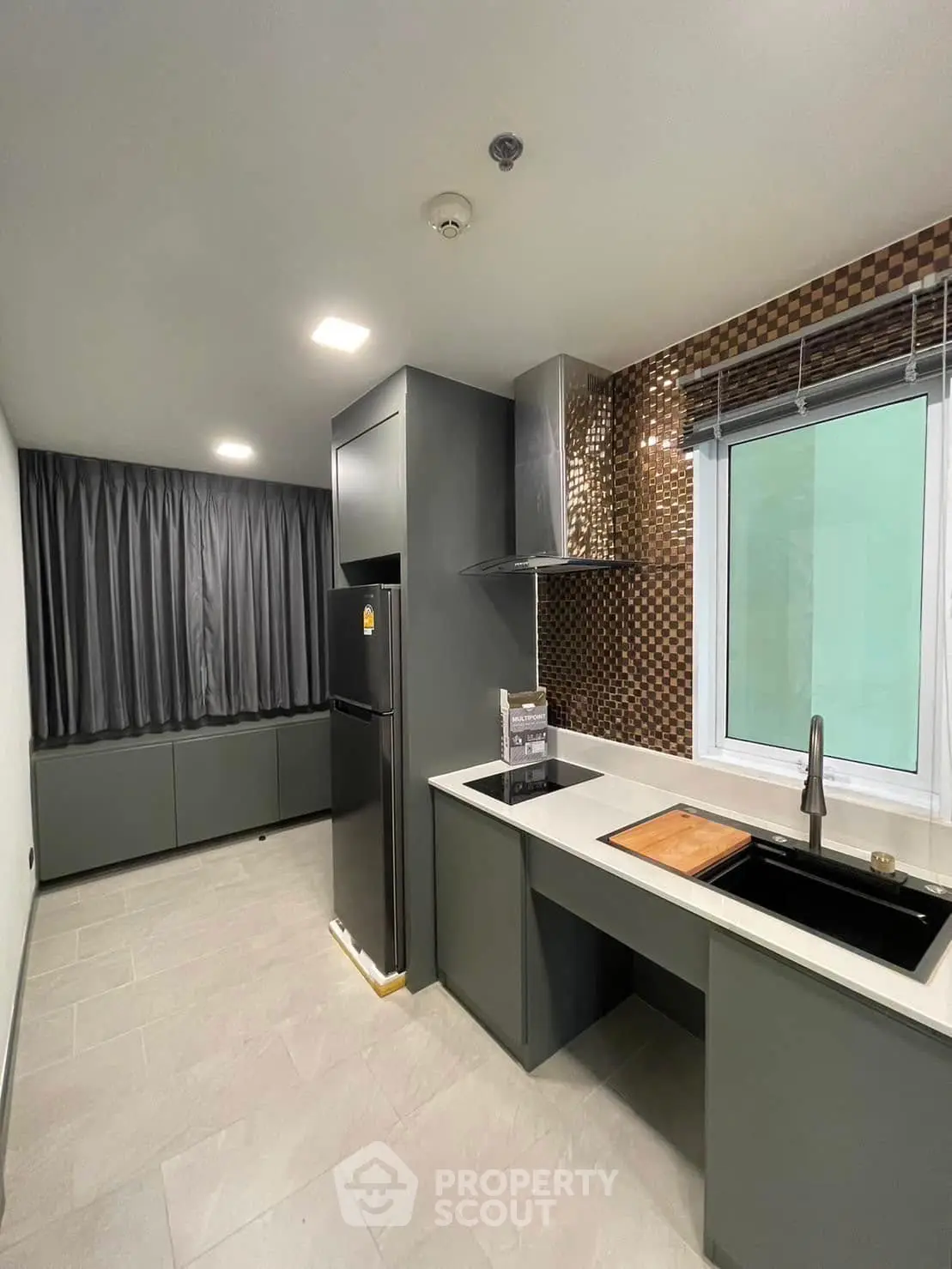 Modern kitchen with sleek design, featuring dark cabinetry and stylish backsplash.