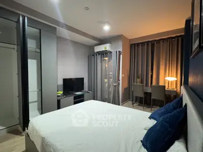 Modern bedroom with cozy lighting and stylish decor, featuring a comfortable bed and a sleek TV setup.
