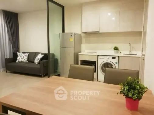 Modern open-plan kitchen and living area with sleek appliances and stylish decor.