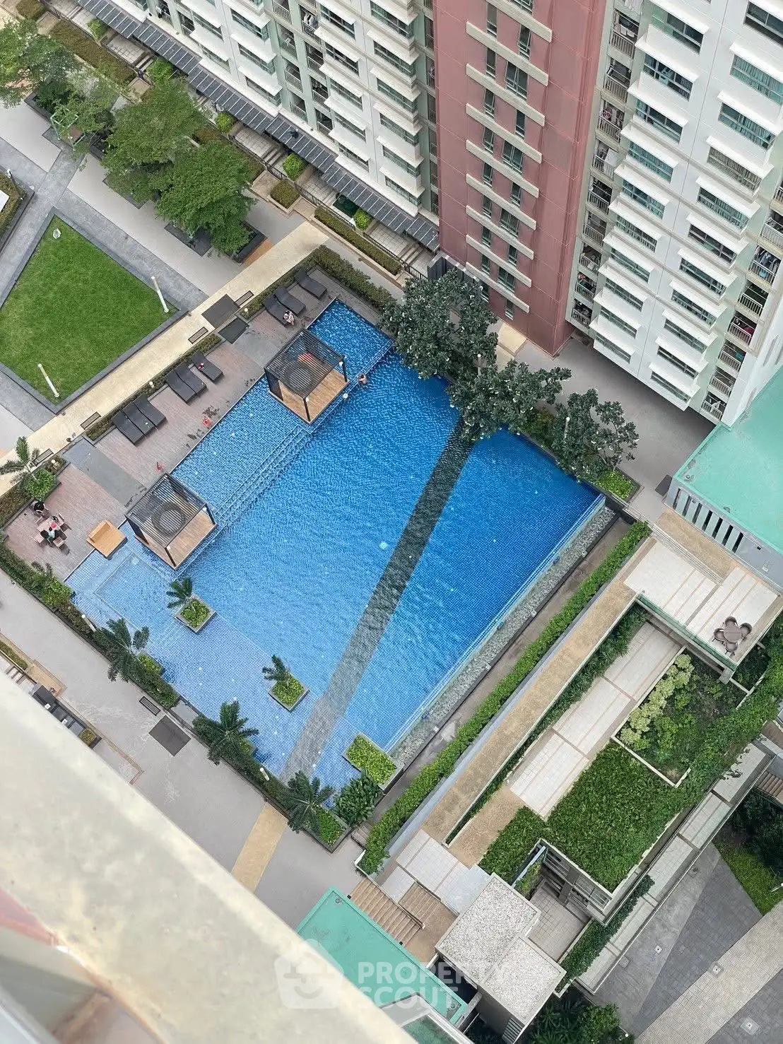 Stunning aerial view of a modern residential complex with a luxurious swimming pool and lush greenery.