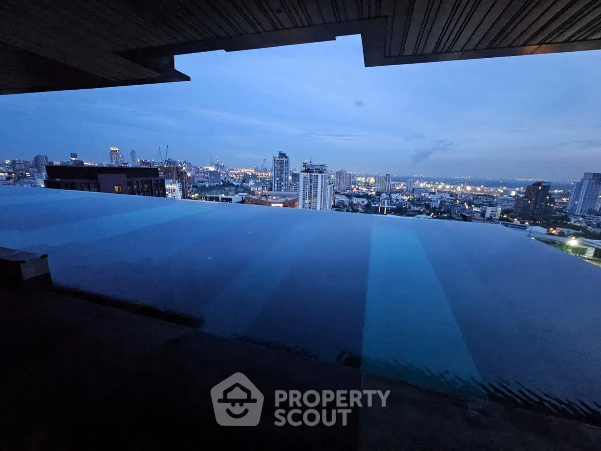 Stunning rooftop infinity pool with breathtaking city skyline view at dusk.