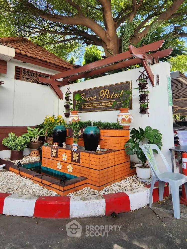 Charming garden entrance with decorative fountain and lush greenery in Bangkok property.